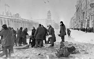 Жители блокадного Ленинграда набирают воду, появившуюся после артобстрела в пробоинах в асфальте. Россия, Ленинград - Невский проспект между Гостиным двором (здание слева) и площадью Островского. Автор фото: Борис Кудояров From Wikimedia Common